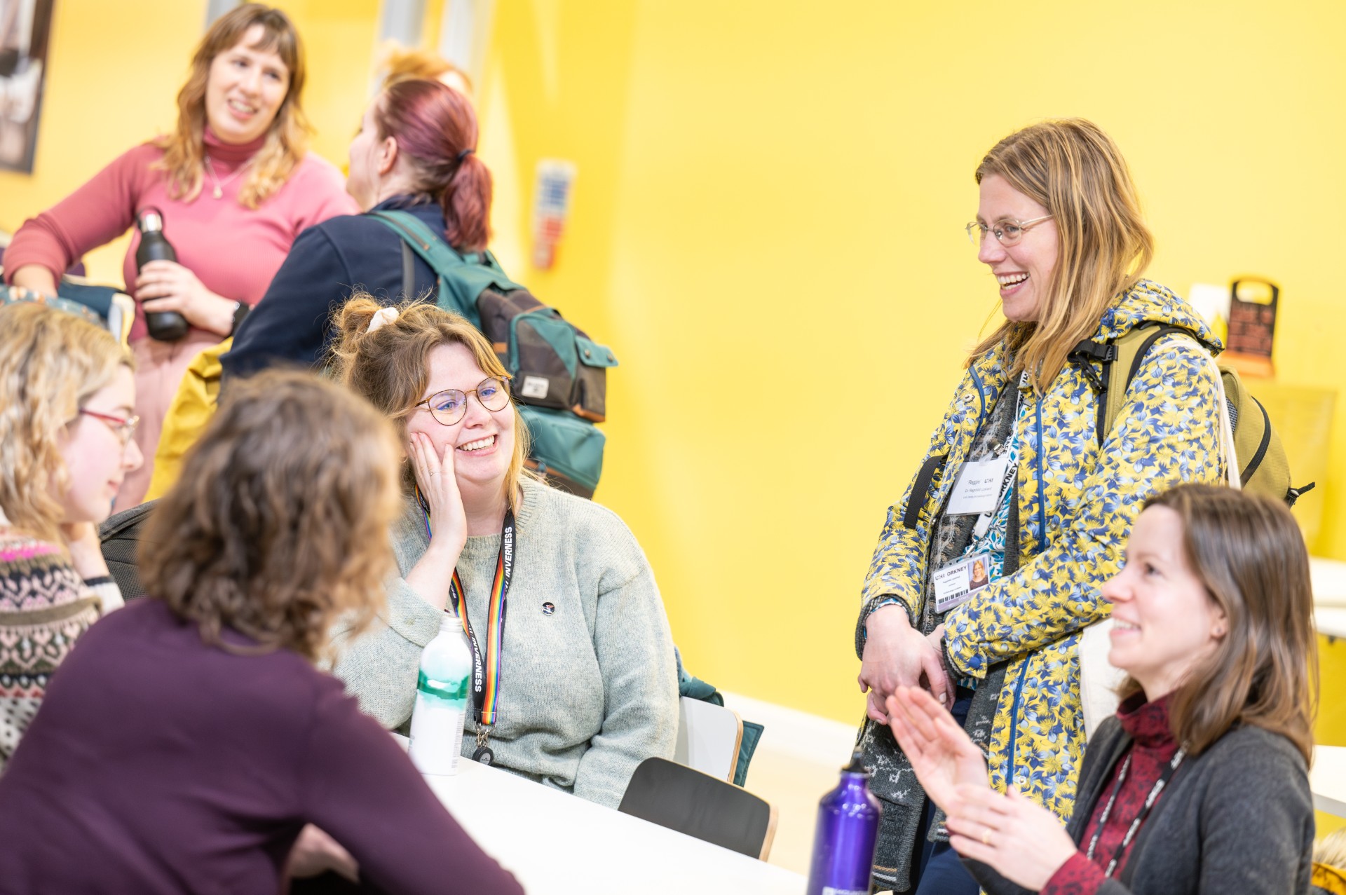 PGRs talking and smiling around a table at a conference